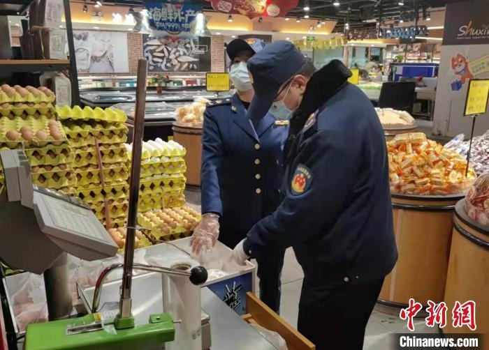 圖為疫情期間，甘肅嘉峪關(guān)市場監(jiān)管局工作人員檢查蔬菜市場?！?柴佳楠 　攝