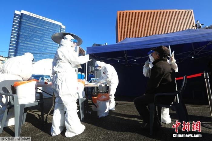 資料圖：韓國(guó)首爾，醫(yī)務(wù)人員對(duì)市民進(jìn)行新冠病毒檢測(cè)。