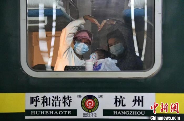 圖為登上轉(zhuǎn)運(yùn)火車的游客向額濟(jì)納比心?！⊥趵?攝