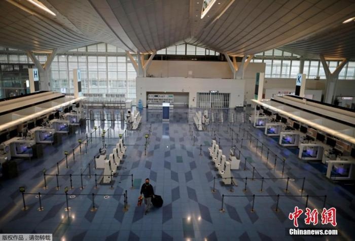 資料圖：日本東京，東京國際機(jī)場，一名乘客在國際航班航站樓的登機(jī)區(qū)。