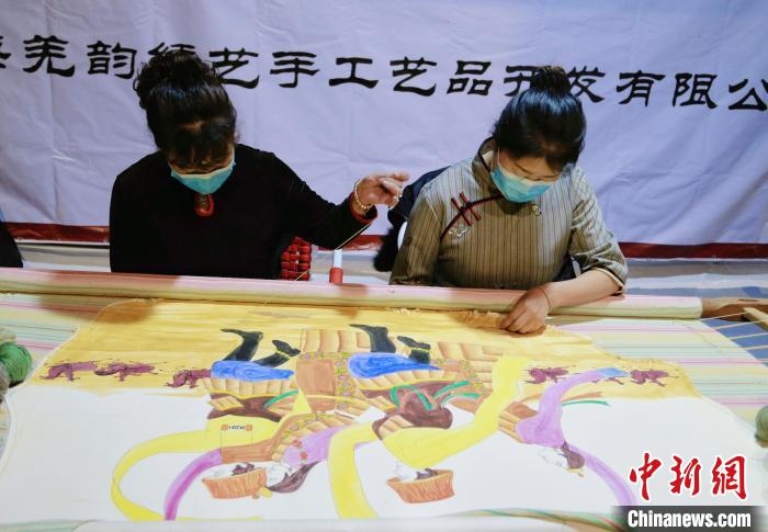 圖為皮繡藝人在市集上“秀”指尖技藝?！●R銘言 攝