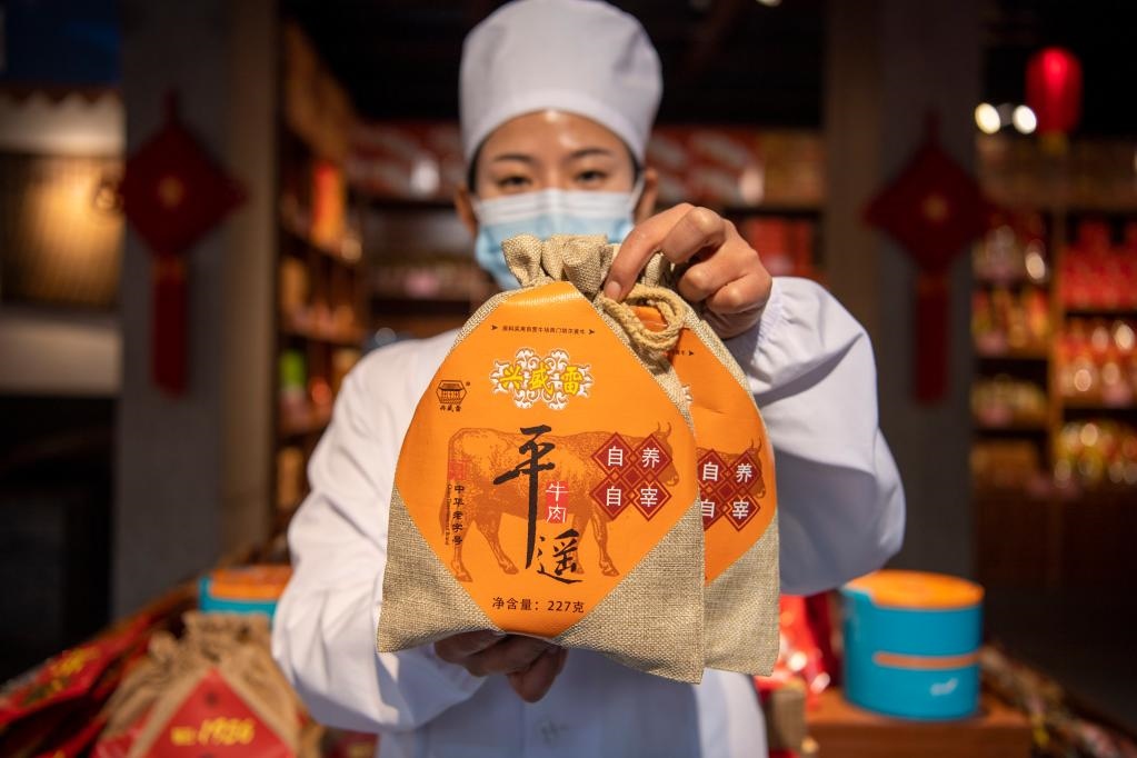 1月27日，在平遙古城南大街的一家平遙牛肉店內(nèi)，工作人員展示一款牛肉產(chǎn)品。新華社記者 楊晨光 攝