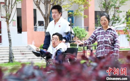 碰上天氣好，朱金祥就會利用休息時間，和鐘華強母親將其推出來賞賞花，曬曬太陽，呼吸一下外面的新鮮空氣。 卓忠偉 攝