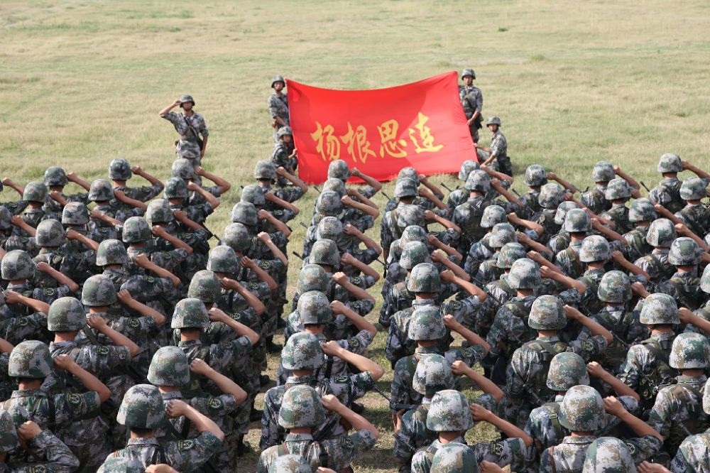 ↑“楊根思連”官兵執(zhí)行任務(wù)前向連旗宣誓（資料照片）。新華社發(fā)