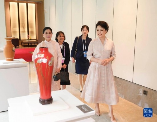 7月27日下午，國家主席習(xí)近平夫人彭麗媛在四川成都會見陪同印度尼西亞總統(tǒng)佐科來華出席第31屆世界大學(xué)生夏季運動會開幕式并訪華的總統(tǒng)夫人伊莉亞娜。這是彭麗媛和伊莉亞娜欣賞成都特色非遺工藝品。新華社記者 丁林 攝