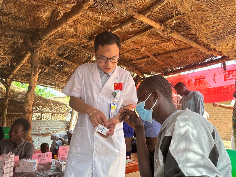 圖為南昌大學第一附屬醫(yī)院病理科主治醫(yī)師張振東為村民解說藥品使用方法。中國駐乍得醫(yī)療隊供圖