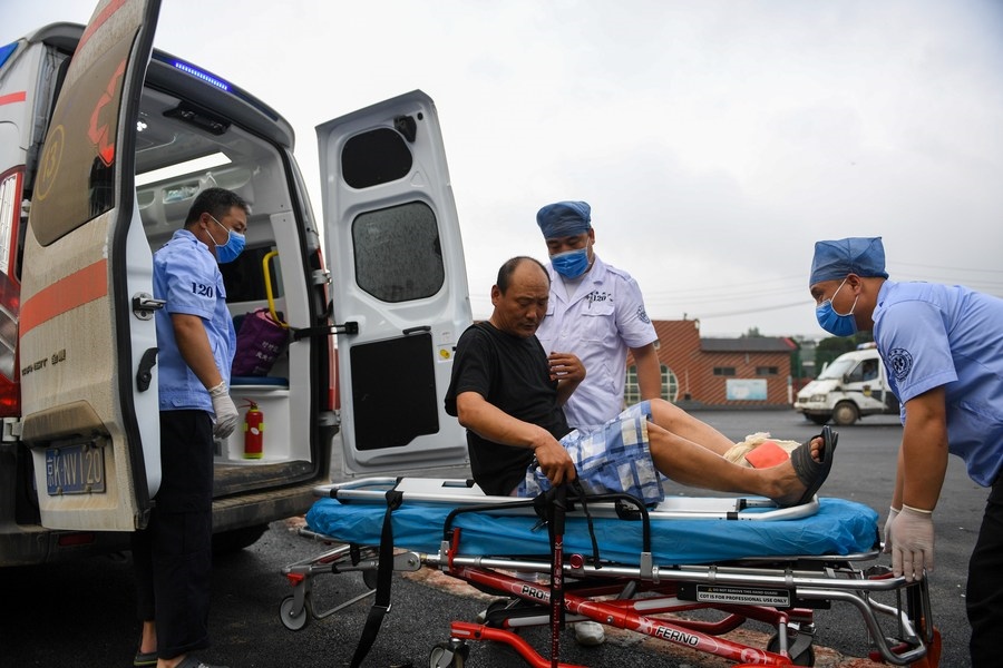 8月1日，在北京市門頭溝區(qū)妙峰山鎮(zhèn)妙峰山民族學(xué)校臨時(shí)安置點(diǎn)，北京急救中心工作人員在轉(zhuǎn)運(yùn)一名受傷村民。新華社記者 鞠煥宗 攝