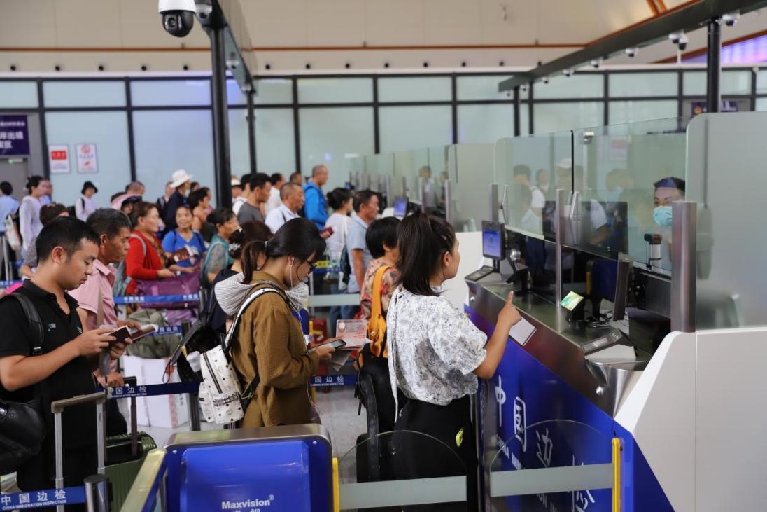 出境旅客在辦理通關手續(xù)。人民網(wǎng)記者 李發(fā)興攝