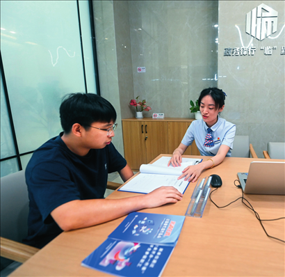 在杭州市臨安區(qū)政務(wù)服務(wù)中心的“為企服務(wù)中心”，黨員志愿者（右）解答企業(yè)主的疑問（2023年7月7日攝）。徐昱攝/本刊