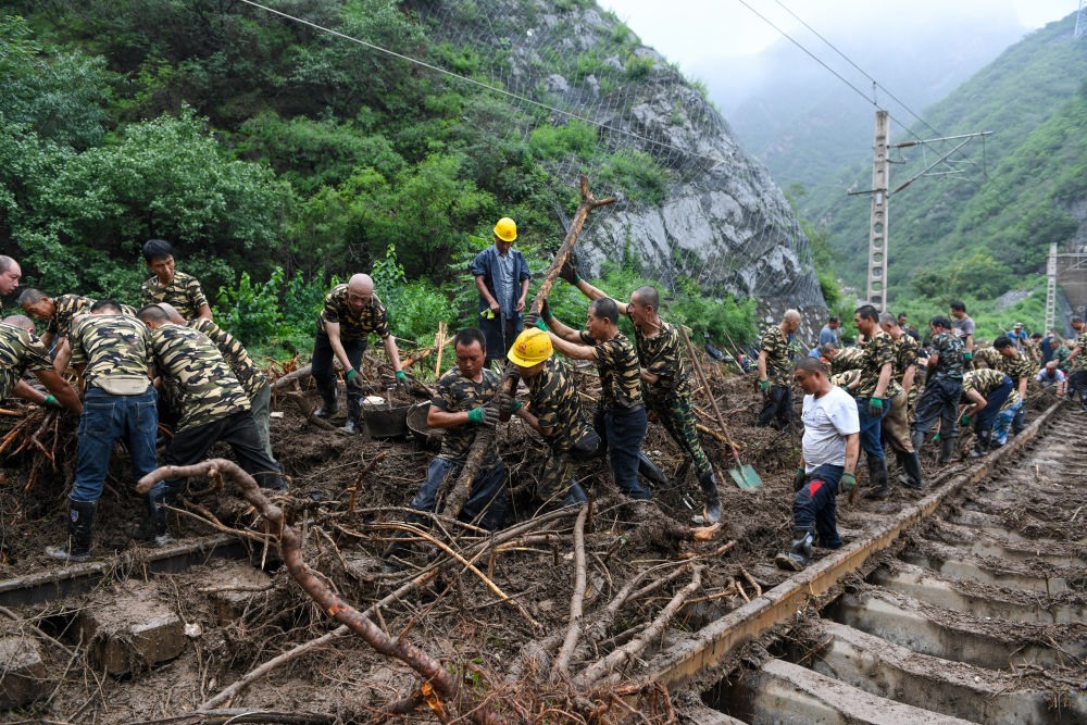 8月1日，在北京市門頭溝區(qū)水峪嘴村附近一段被阻斷的鐵路線上，中鐵六局工作人員在清理軌道上的雜物，全力恢復(fù)交通。新華社記者 鞠煥宗 攝