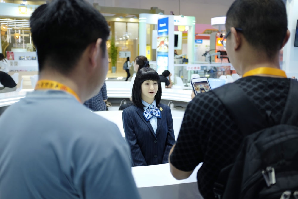 9月1日，媒體記者在國(guó)家會(huì)議中心與服務(wù)機(jī)器人互動(dòng)。新華社記者 劉夢(mèng)琪 攝