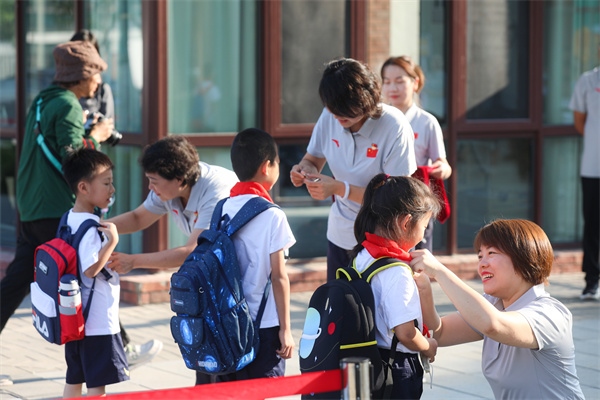 8月30日，雄安史家胡同小學(xué)學(xué)生體驗(yàn)學(xué)校生活。老師為學(xué)生佩戴?；铡? /></p> <p style=