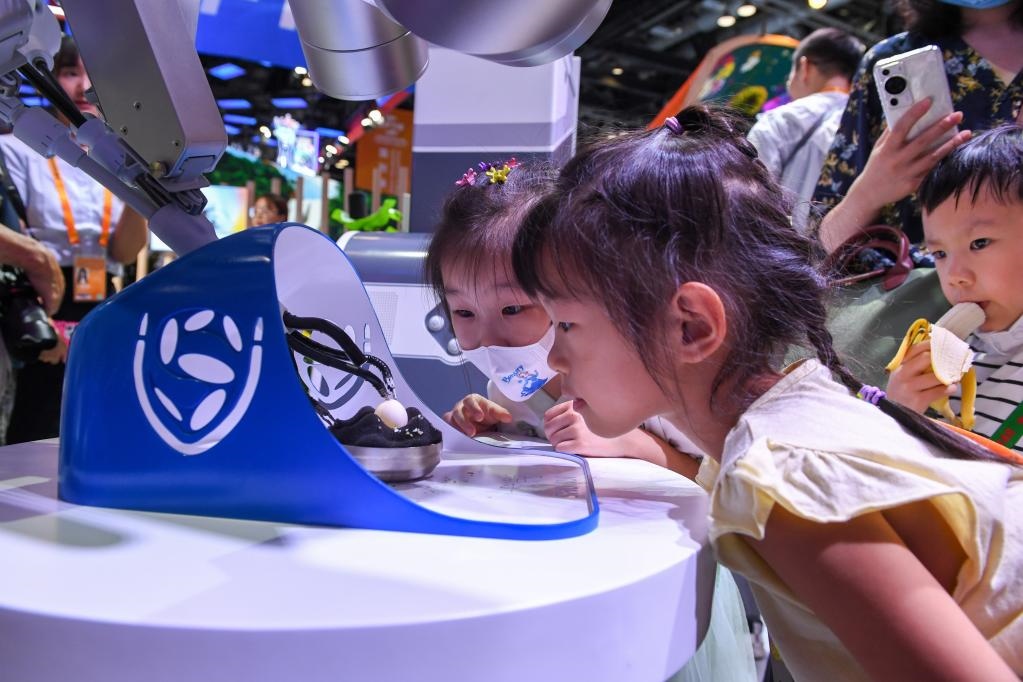 9月3日，幾名小朋友在國(guó)家會(huì)議中心觀看單孔腔鏡手術(shù)機(jī)器人展示。新華社記者 鞠煥宗 攝