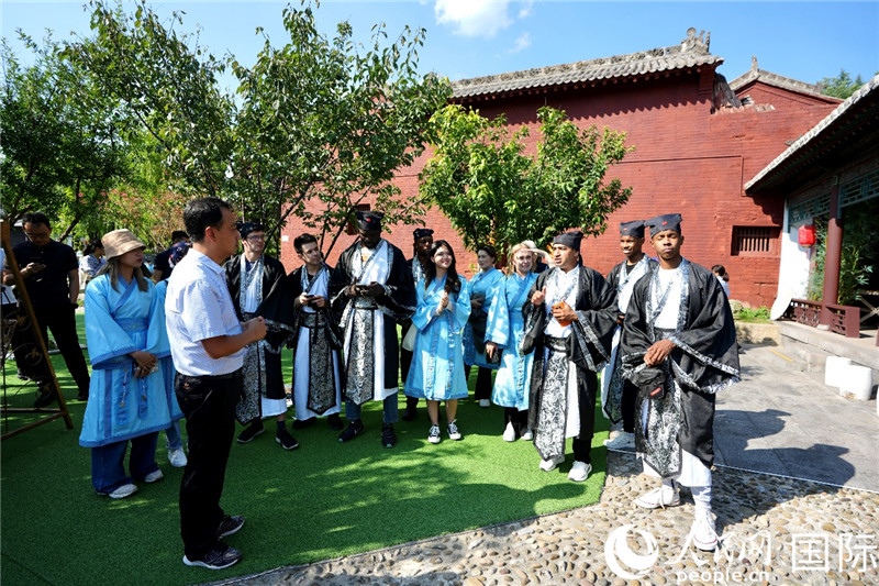 圖為選手們聽導(dǎo)游講解。人民網(wǎng) 盧鵬宇攝