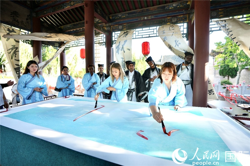 選手們提筆書寫“家園”二字。人民網(wǎng) 盧鵬宇攝