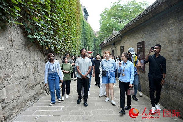 選手們認(rèn)真聆聽導(dǎo)游講解。人民網(wǎng) 盧鵬宇攝