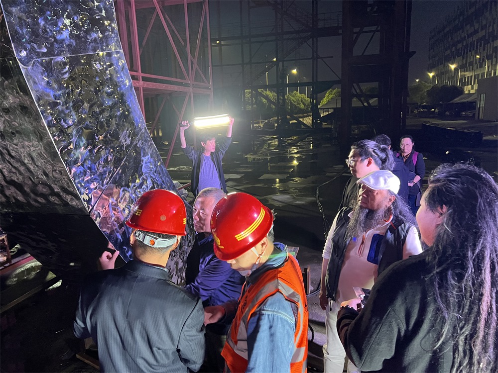 林崗（右二）和團隊查看主火炬制作進度。受訪者供圖