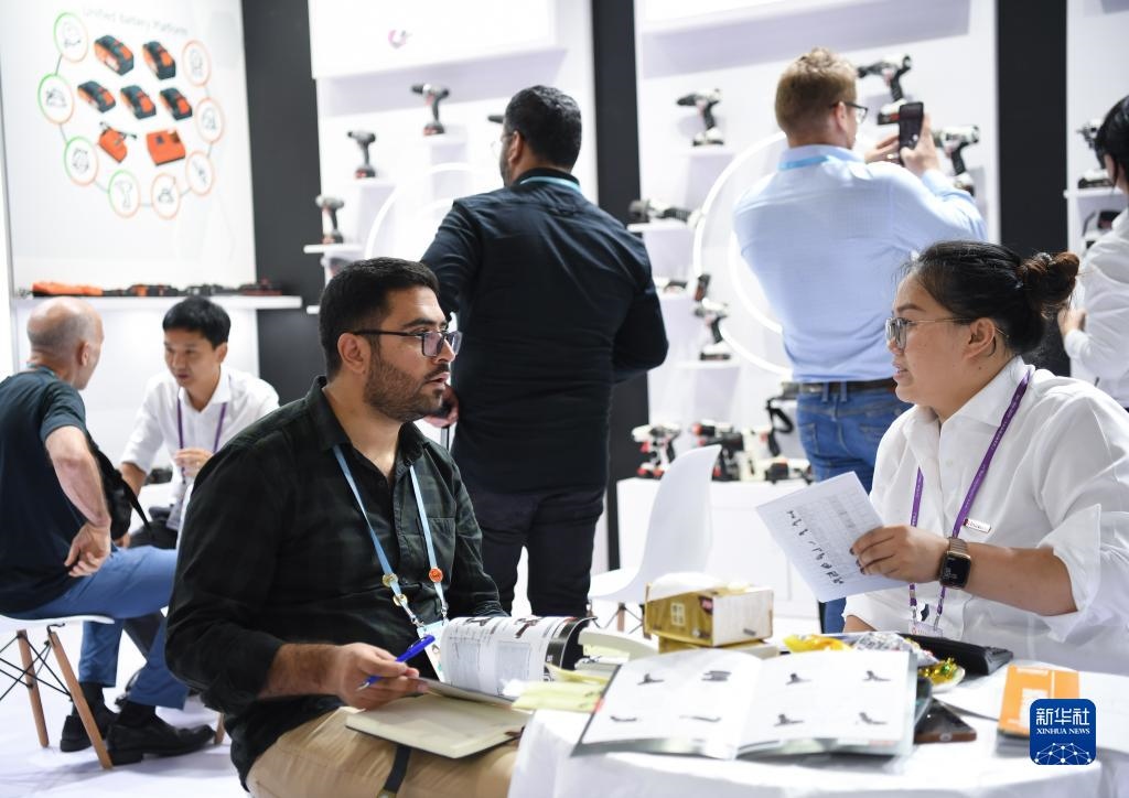 10月15日，在一家電動工具展臺，外國采購商在洽談業(yè)務(wù)。新華社記者 鄧華 攝