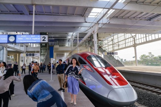  10月17日，在印度尼西亞萬隆德卡魯爾站，乘客在站臺上和雅萬高鐵高速動車組列車合影。新華社記者 徐欽 攝