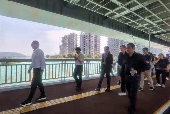 10月24日，2023“一帶一路”媒體合作論壇聯(lián)合采訪團團員走在清水塘大橋景觀通道上。本報記者 常雯宜攝