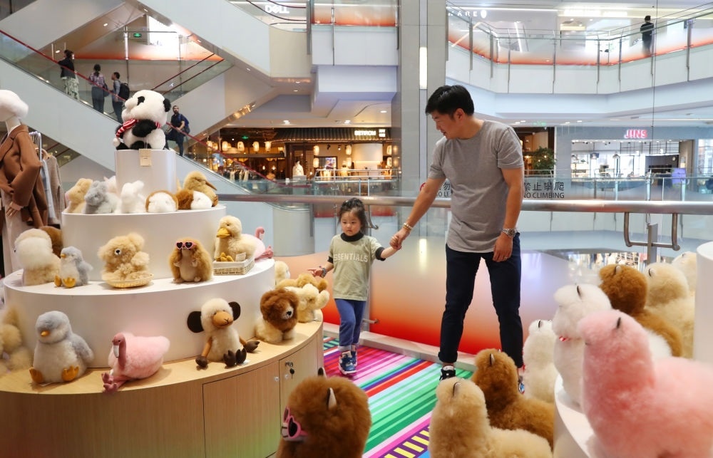 2023年11月2日，顧客在溫暖駝品牌專柜內(nèi)選購。連續(xù)六年參加進(jìn)博會的秘魯羊駝制品品牌溫暖駝在上海市中心商場開設(shè)了專柜。新華社記者 方喆 攝