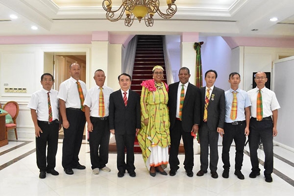 多米尼克總統(tǒng)伯頓和駐多米尼克大使林先江與中國(guó)農(nóng)業(yè)技術(shù)專(zhuān)家組合影。中國(guó)駐多米尼克大使館供圖