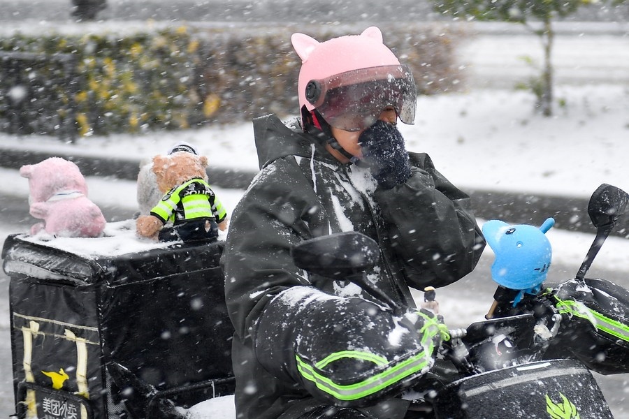 11月6日，在長春市街頭，一名外賣員在雪中騎行。新華社記者 許暢 攝