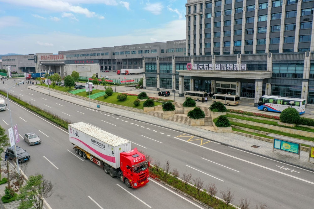 2023年10月11日，滿載筆記本電腦配件、發(fā)電機(jī)組件等產(chǎn)品的西部陸海新通道跨境公路班車從重慶南彭公路保稅物流中心駛出，將途經(jīng)廣西憑祥，直達(dá)越南（無人機(jī)照片）。新華社記者 黃偉 攝