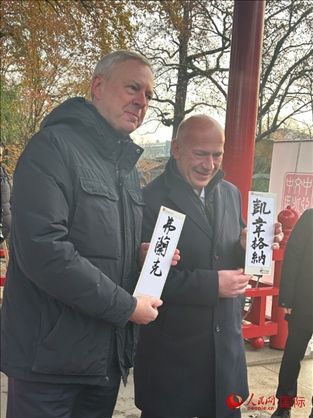 柏林市長韋格納（右）、動(dòng)物園監(jiān)事會(huì)主席布魯克曼（左）手持中國文化中心工作人員現(xiàn)場手書的中文名字。人民網(wǎng)記者 徐馨攝