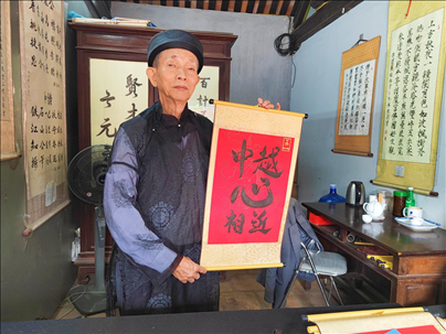 越南首都河內(nèi)文廟內(nèi)，阮明珠展示“中越心相近”書(shū)法作品。