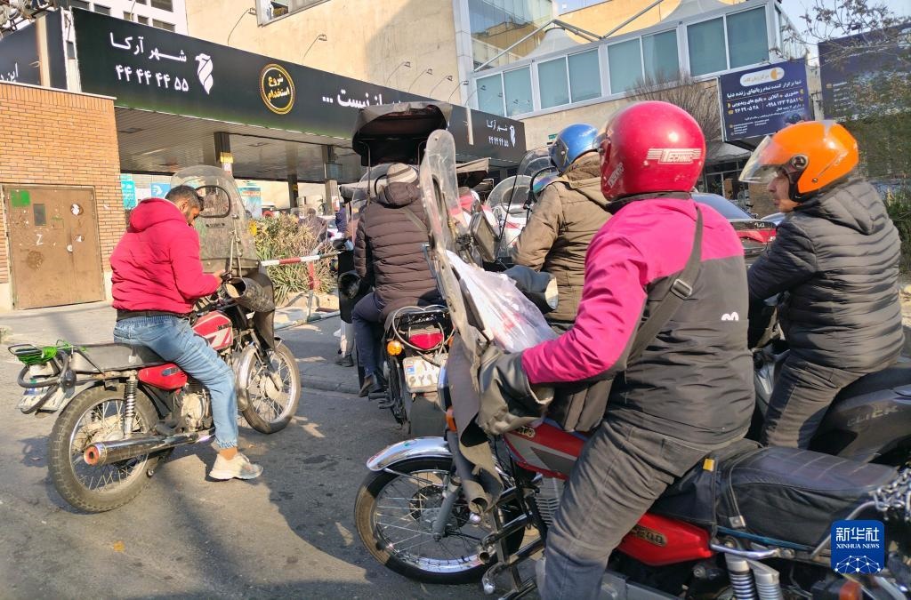 12月18日，摩托車在伊朗首都德黑蘭的一家加油站外等待加油。新華社記者 沙達(dá)提 攝