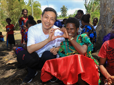 2023年12月18日，中國(guó)駐瓦努阿圖大使李名剛和前來觀看瓦努阿圖公路項(xiàng)目二期馬勒庫拉段移交儀式的當(dāng)?shù)鼐用窈嫌?。人民網(wǎng) 賀吉攝