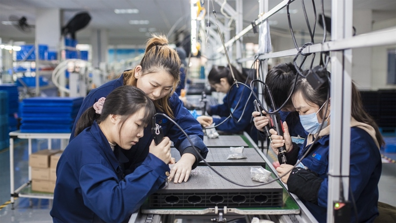 在新亞勝光電的產(chǎn)品線上，工人正進(jìn)行產(chǎn)品組建和安裝布線。受訪者供圖