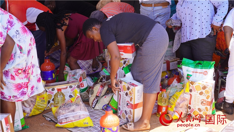 當(dāng)?shù)厣鐓^(qū)家庭領(lǐng)取物資。人民網(wǎng) 張茜攝