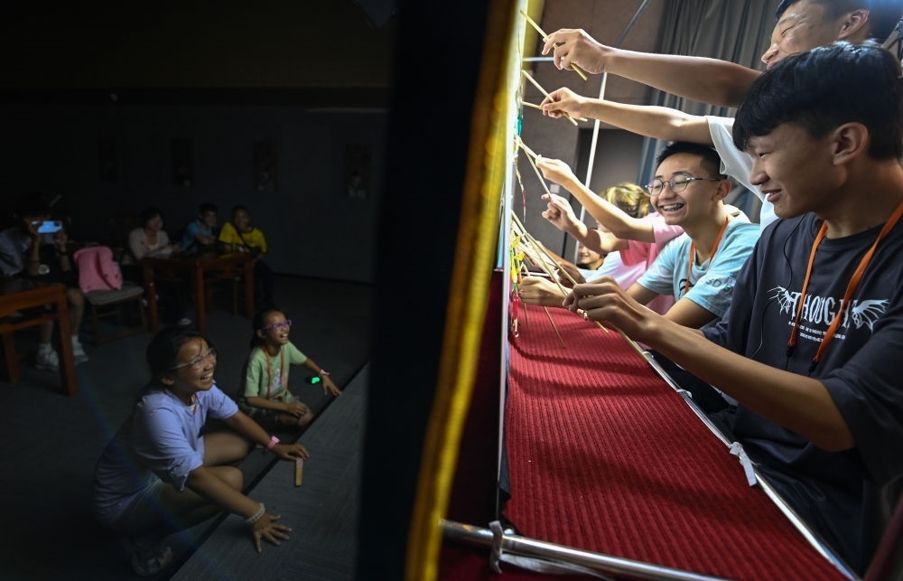 2023年8月8日，進(jìn)行暑期研學(xué)的學(xué)生在位于陜西省西安市的中國秦腔藝術(shù)博物館體驗(yàn)皮影戲演出。新華社記者 鄒競一 攝