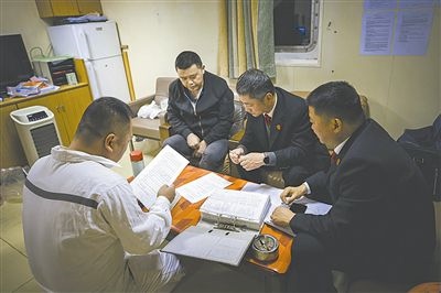圖②：法官向船長講解相關法律規(guī)定，查看船舶資料，并與船方辦理扣押船舶的手續(xù)。