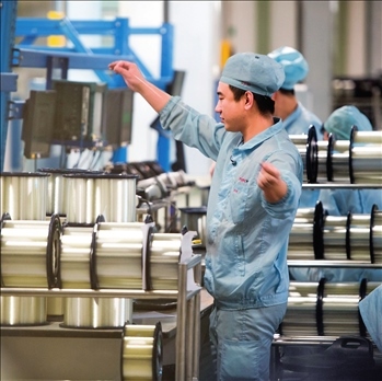 在位于武漢的長(zhǎng)飛光纖光纜股份有限公司光纖生產(chǎn)車間內(nèi)，工作人員對(duì)光纖進(jìn)行檢測(cè)（資料圖片）。肖藝九攝/本刊