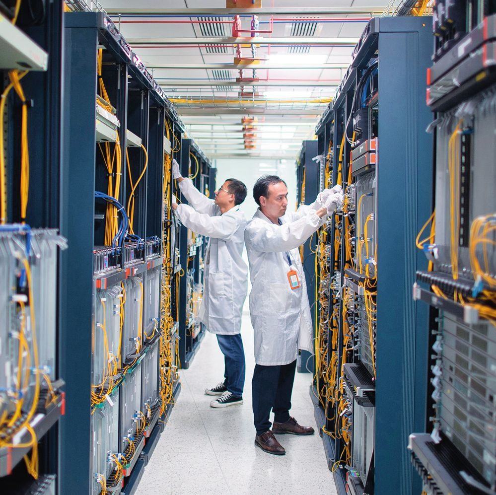 在位于武漢中國(guó)光谷的光電器件研發(fā)制造商——武漢光迅科技股份有限公司生產(chǎn)車間內(nèi)，技術(shù)人員在光模塊生產(chǎn)線作業(yè)（2023年4月11日攝）。程敏攝/本刊