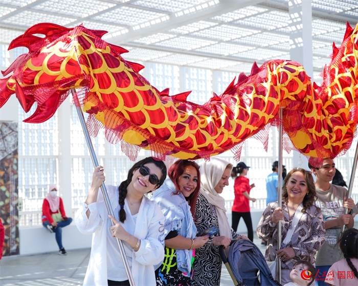 游客體驗舞龍。 人民網(wǎng) 塔里克·易卜拉欣攝