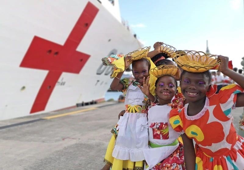 2018年10月，在安提瓜和巴布達首都圣約翰，當?shù)匦∨笥焉泶﹤鹘y(tǒng)服裝歡迎中國海軍“和平方舟”醫(yī)院船首次到訪。