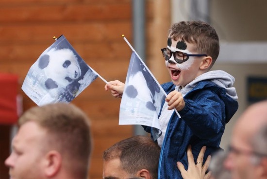  2023年7月26日，在法國(guó)圣艾尼昂市博瓦勒野生動(dòng)物園外，一名兒童等待送別熊貓“圓夢(mèng)”。新華社記者 高靜 攝