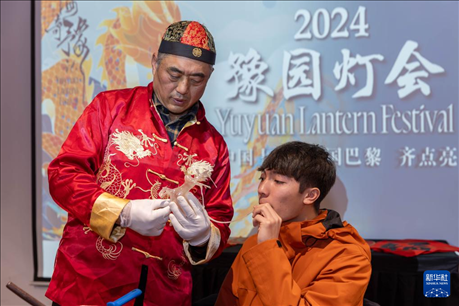 1月28日，在上海豫園舉行的民俗活動上，美國馬斯卡廷中學(xué)學(xué)生在非遺傳承人的指導(dǎo)下吹糖偶。 新華社記者 王翔 攝