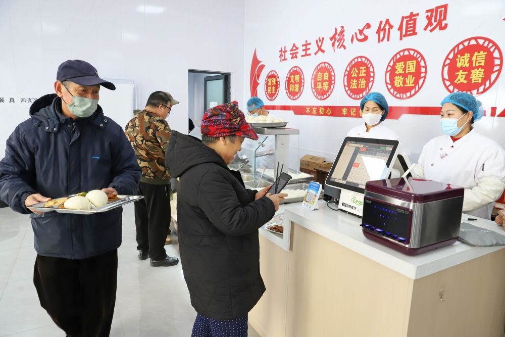 △2024年2月1日，市民在河北涿州市雙塔街道永濟秀園小區(qū)便民食堂內(nèi)購買午餐。