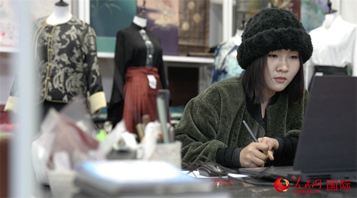 1月23日，在山東省菏澤市曹縣有愛云倉直播基地，張子晨正在設(shè)計漢服。 人民網(wǎng)記者 袁蒙攝