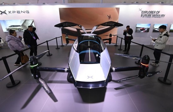 2023年12月1日，在鏈博會(huì)智能汽車鏈展區(qū)小鵬汽車展臺(tái)，參觀者觀看一臺(tái)智能飛行器。新華社記者蔡湘鑫攝