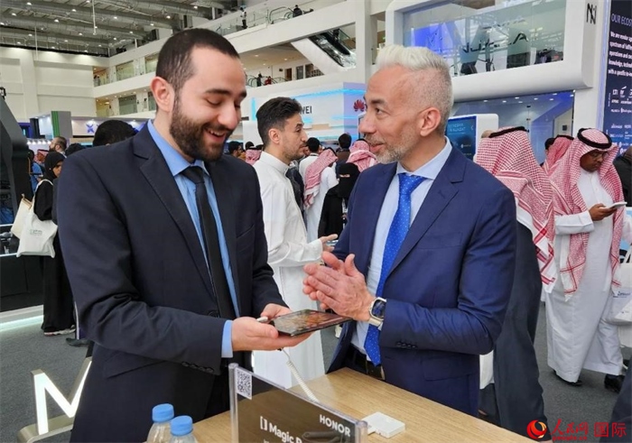 兩名觀眾在榮耀手機(jī)展臺(tái)前交流。人民網(wǎng)記者 管克江攝