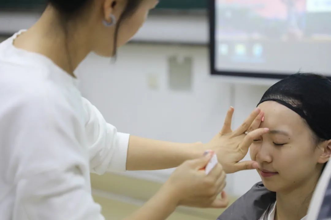 課堂上，一名學(xué)生在體驗上戲妝。學(xué)校供圖