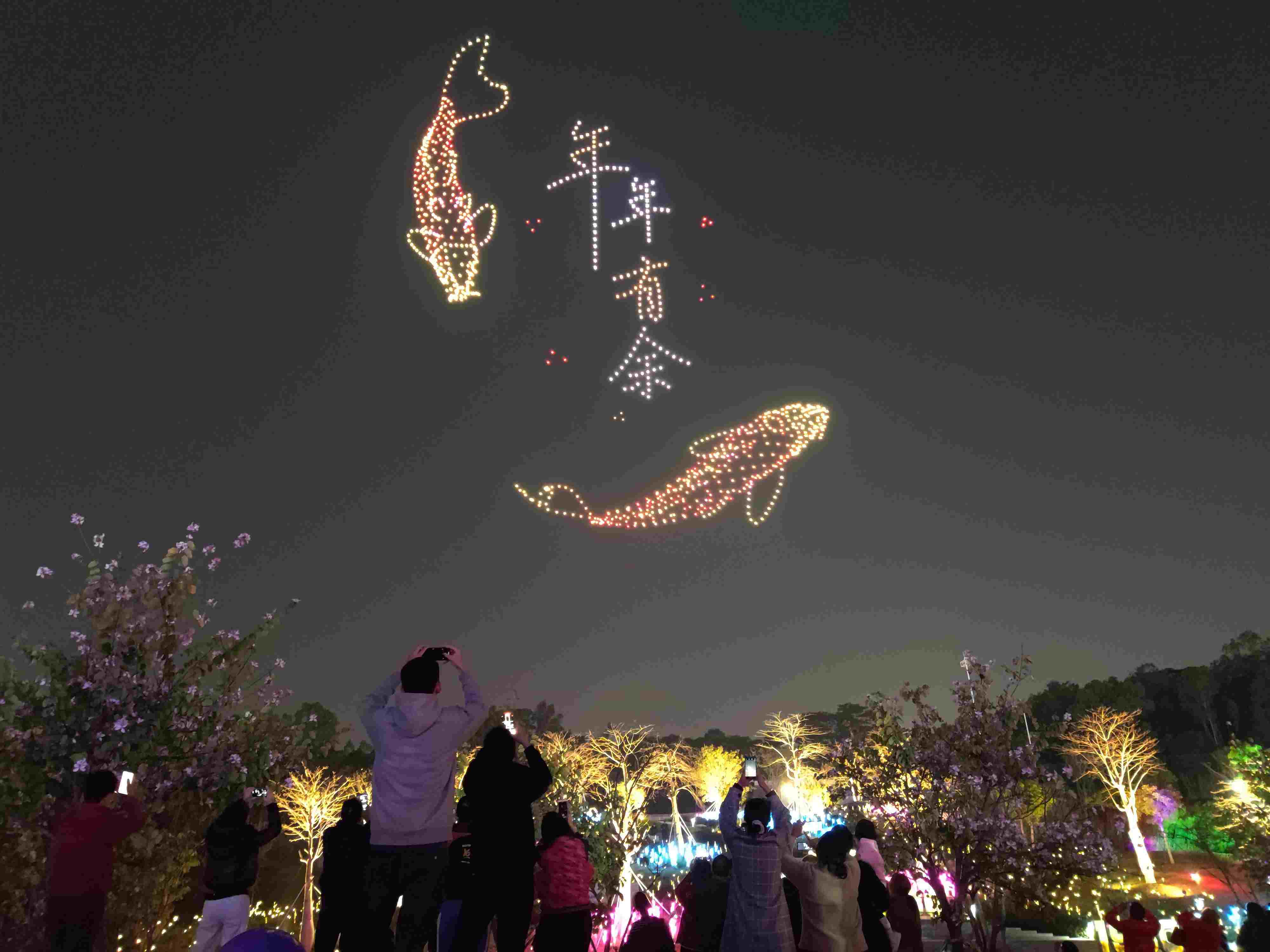 △ 2024年2月10日，深圳北站中心公園，春節(jié)主題無(wú)人機(jī)燈光秀引來(lái)眾多游客駐足觀看。