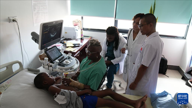 3月4日，在多米尼克羅索的中多友誼醫(yī)院，援多醫(yī)療隊成員、南方醫(yī)科大學第五附屬醫(yī)院心血管內(nèi)科主治醫(yī)師駱志鵬與當?shù)蒯t(yī)生共同診療。新華社記者 王朝 攝