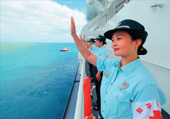 中國(guó)海軍“和平方舟”號(hào)醫(yī)院船結(jié)束訪問(wèn)湯加時(shí)，任務(wù)官兵中的文職人員向歡送人群揮手告別（2023年8月4日攝）。徐巍攝/本刊